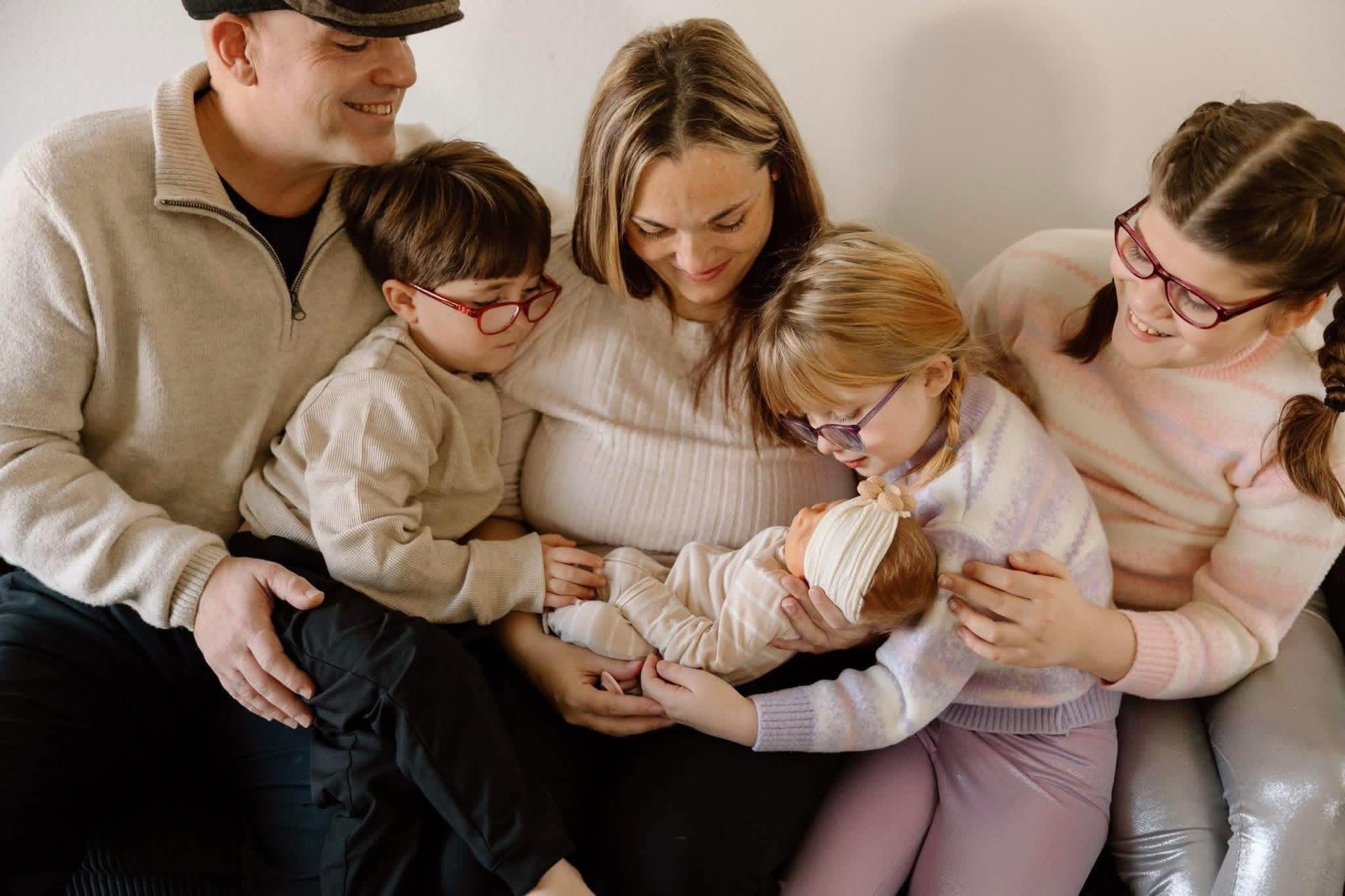 The Esposito family — Anthony, his wife, and their four children on the couch, the newest one asleep in the middle.